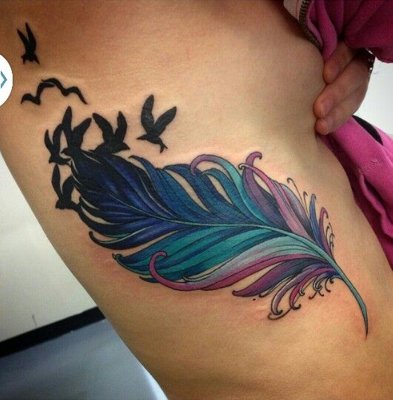 Tatouage plume colorée avec des tons de bleu et de rose et avec des oiseaux noirs